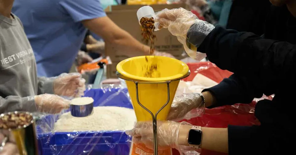 A hand pouring beans into a funnel